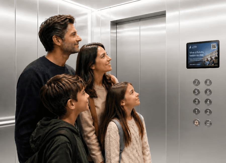 Familia en un ascensor moderno observando una pantalla digital de Icaro Lift